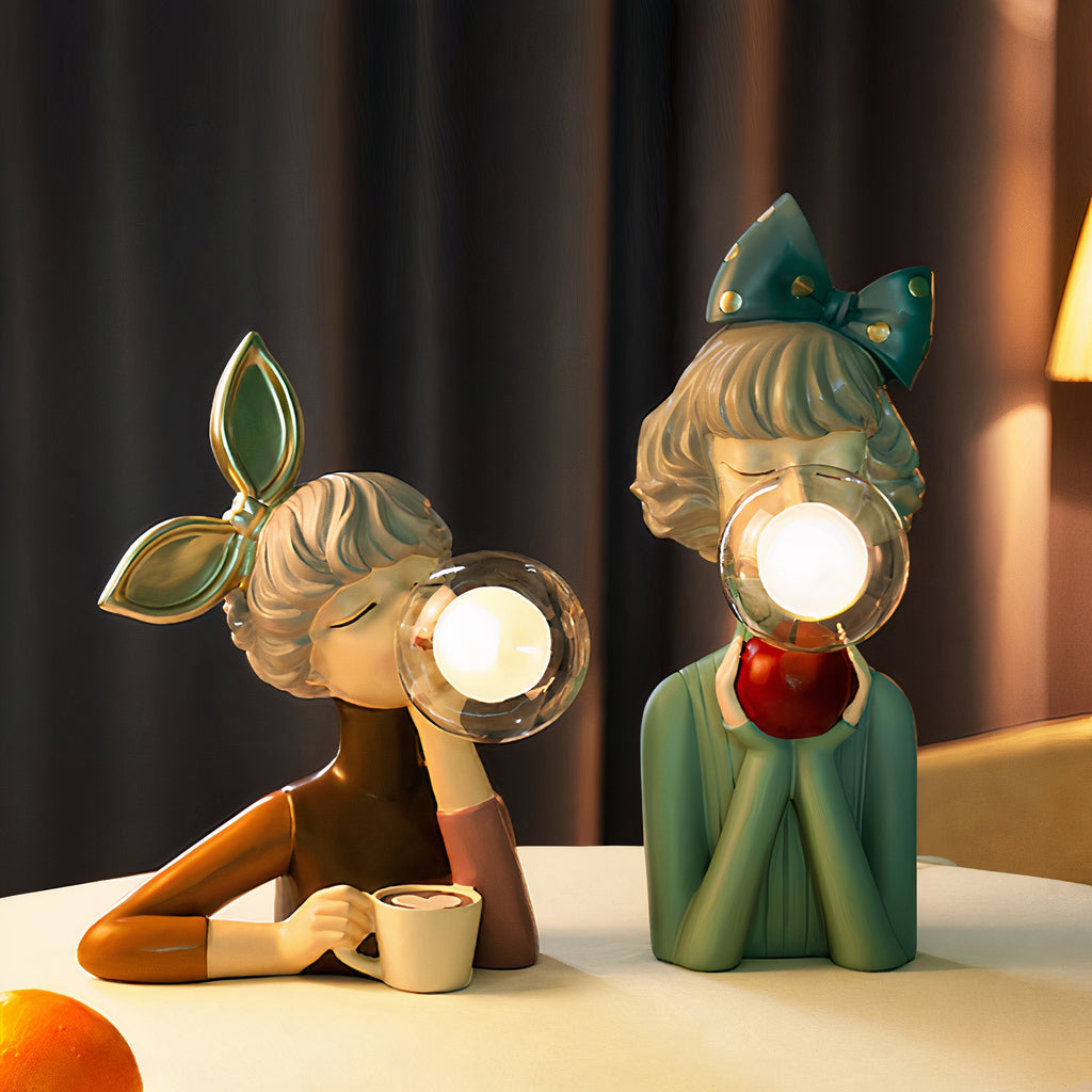 Figure lamps holding a coffee cup and a red apple, softly lit