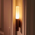 LED torch light glowing warmly on a wall beside a door