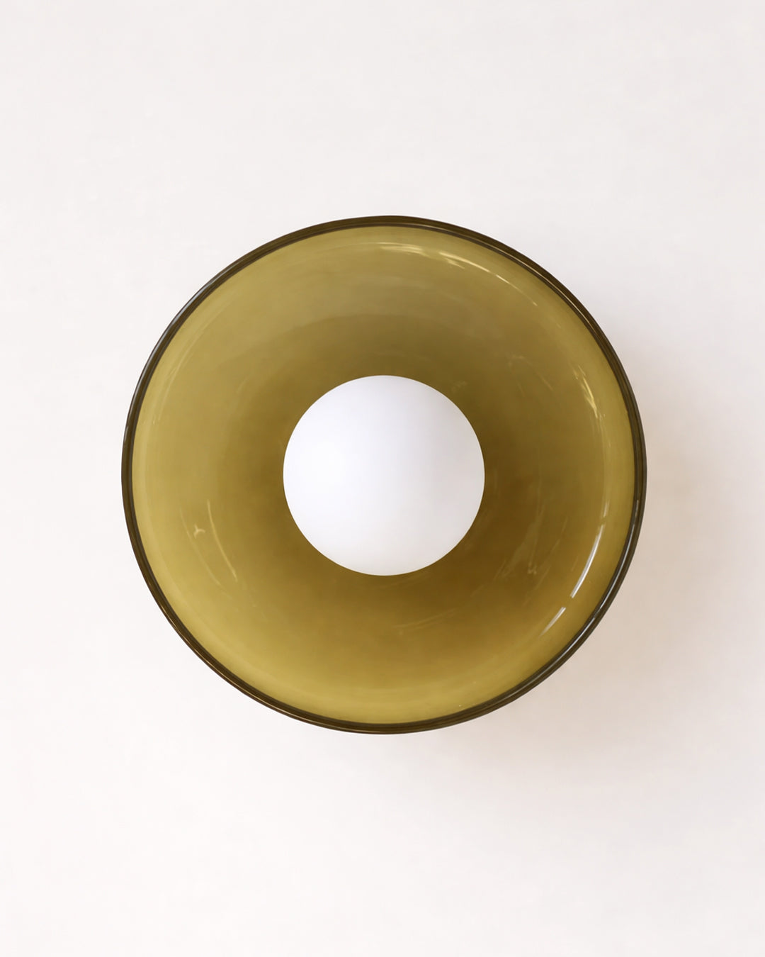Round glass wall light fixture with white globe bulb