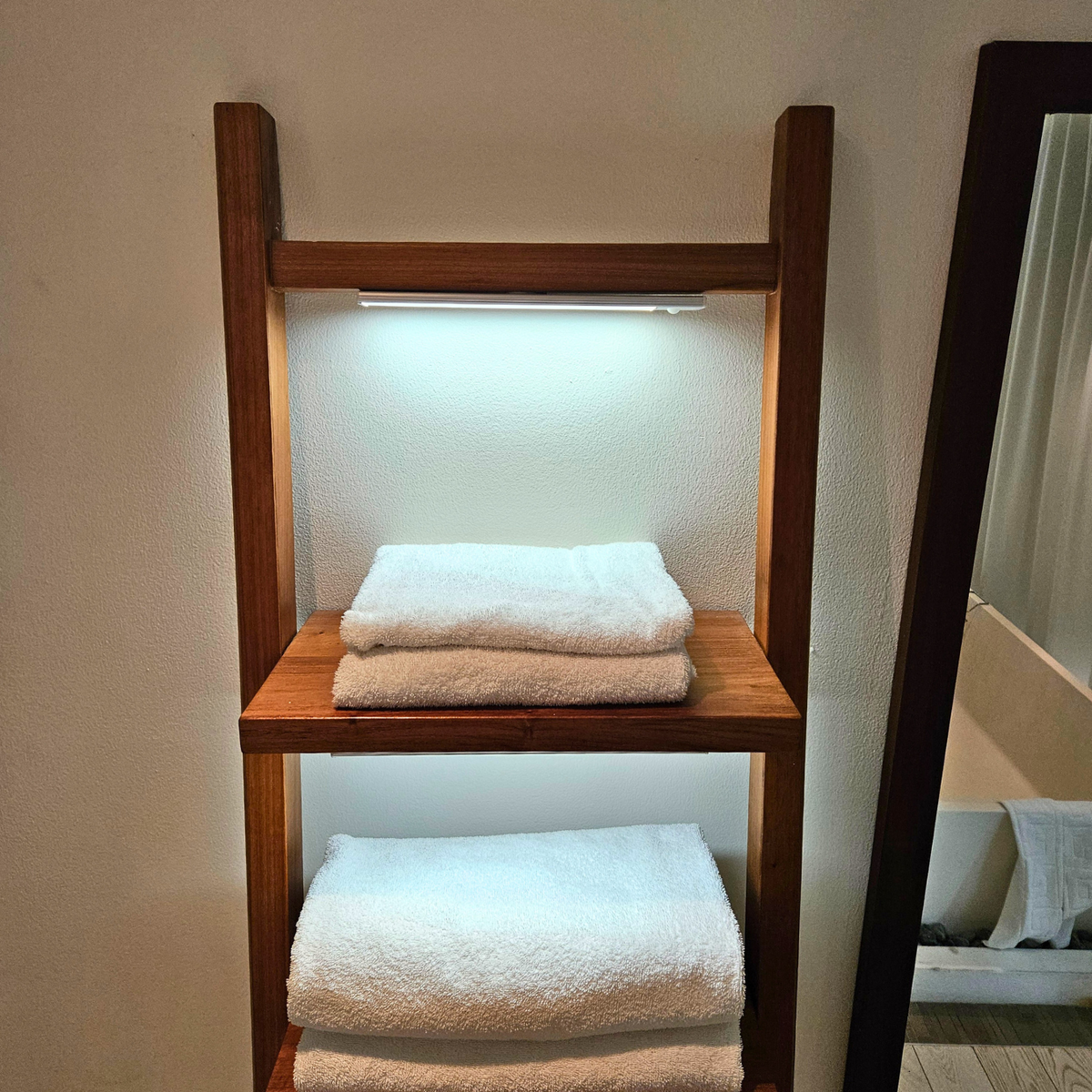 Rechargeable LED bar under a wooden towel ladder shelf
