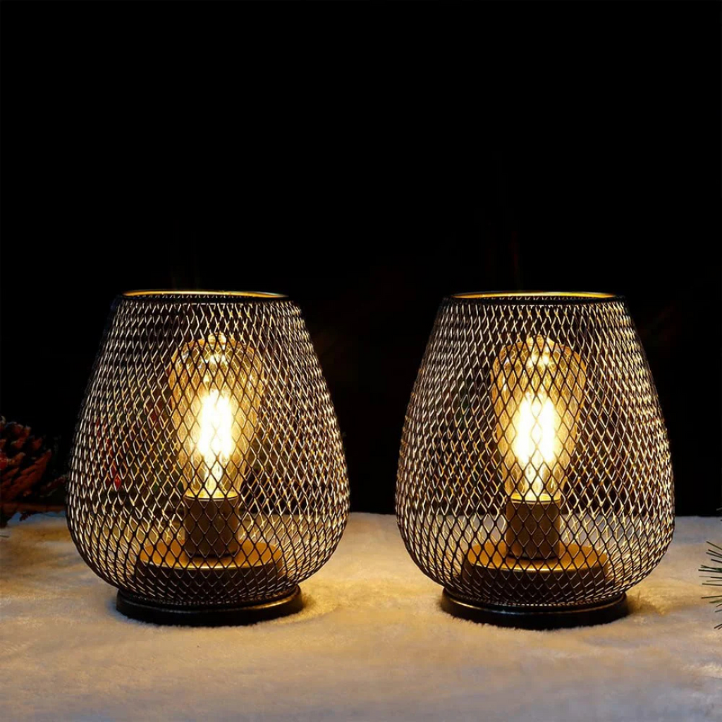 Pair of black metal mesh lamps glowing in a dark room