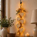 Lit wooden heart wall hanging above a table with a candle