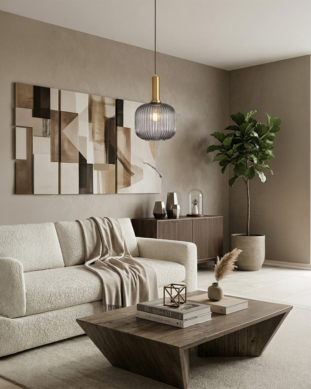 Smoky gray glass pendant light with gold fitting above sofa