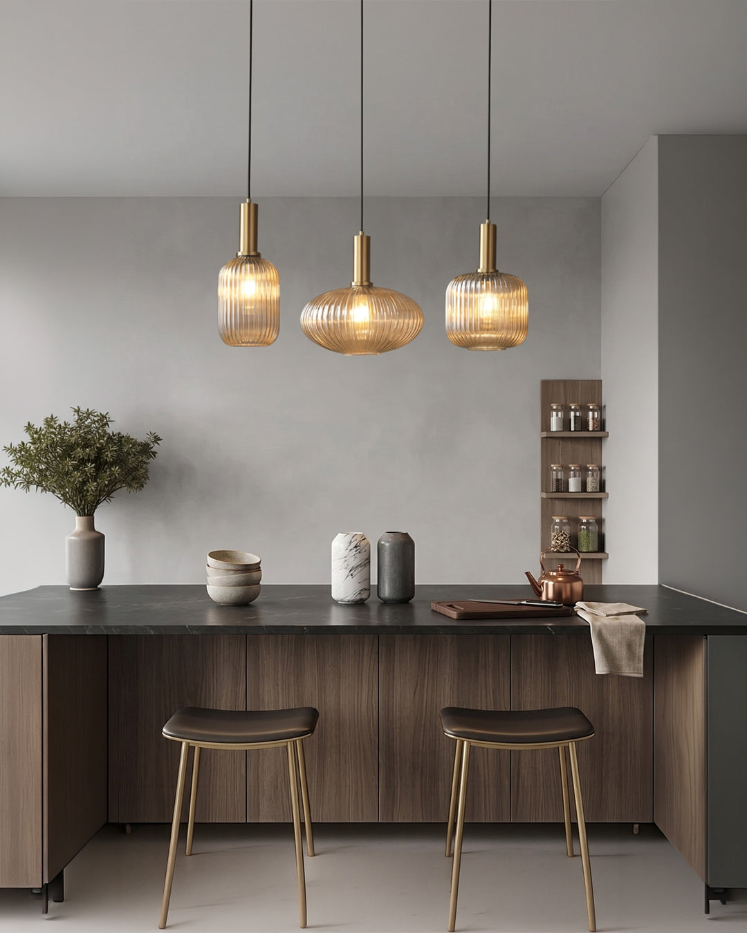 Three cognac island pendant lights above a dark kitchen counter