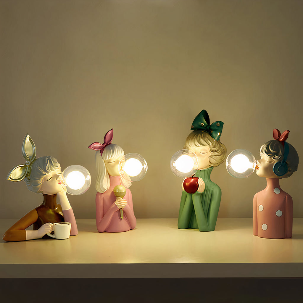 Four sculptural modern table lamps glowing on a warm shelf
