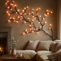 Cherry blossom LED wall lights glowing above a cozy living room sofa