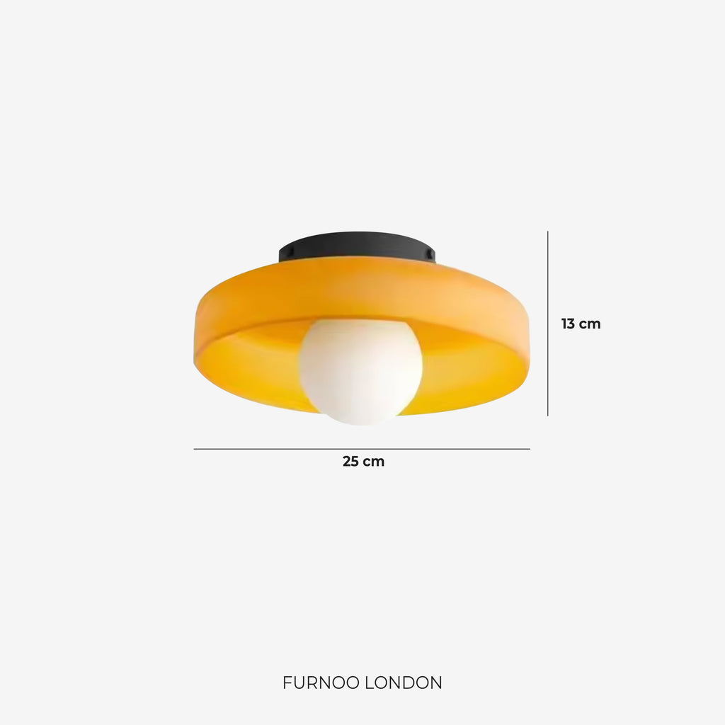 Round colored glass wall light on textured wall