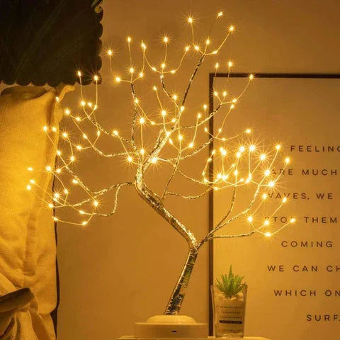 Small table lamp with silver branches beside a framed print