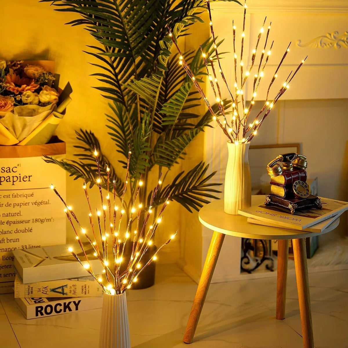 Two sets of warm white branch lights on floor and side table