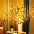 USB light branches glowing warm white in a ceramic vase