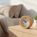 Silent wooden alarm clock on a light wood nightstand by a sofa