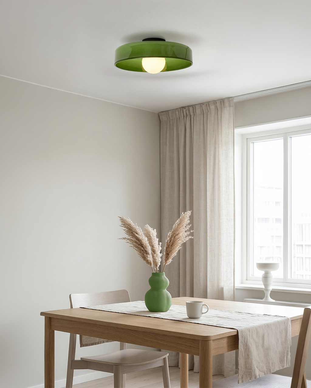 Green glass ceiling light above a wooden dining table