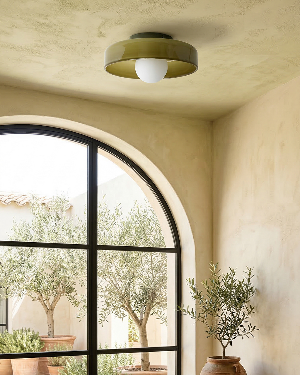 Tawny olive flush mount light on ceiling near arched window