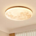 Moon LED ceiling light with light wood rim glowing warm white