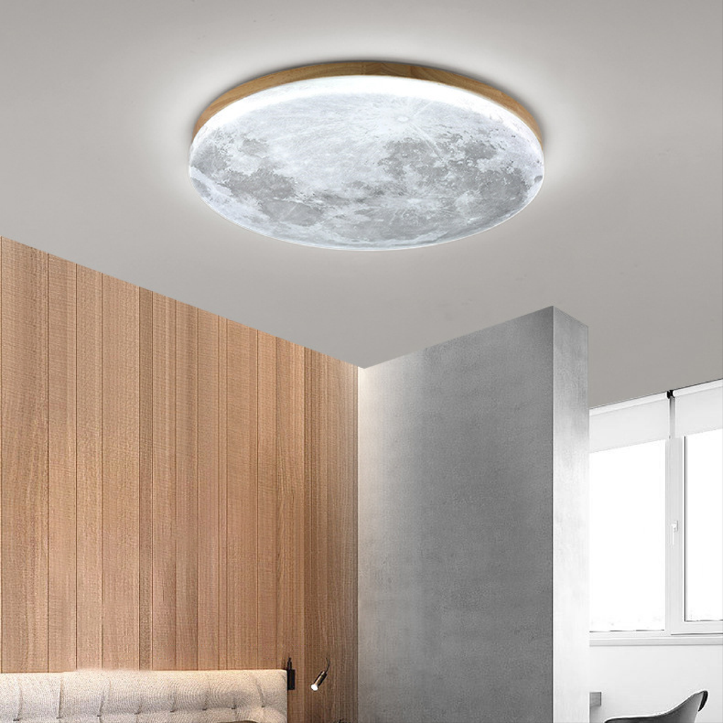 Light wood moon LED ceiling light in cool white over wood paneling