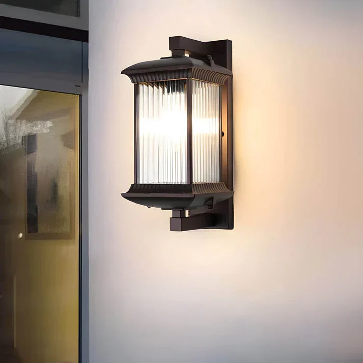 Modern outdoor wall lamp with fluted glass beside a doorway