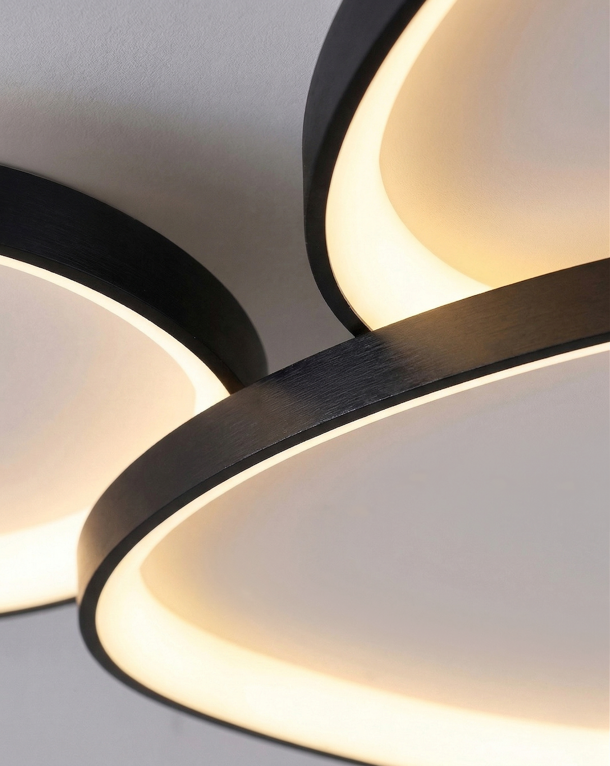 Black three-pebble ceiling fixture in a calm modern room