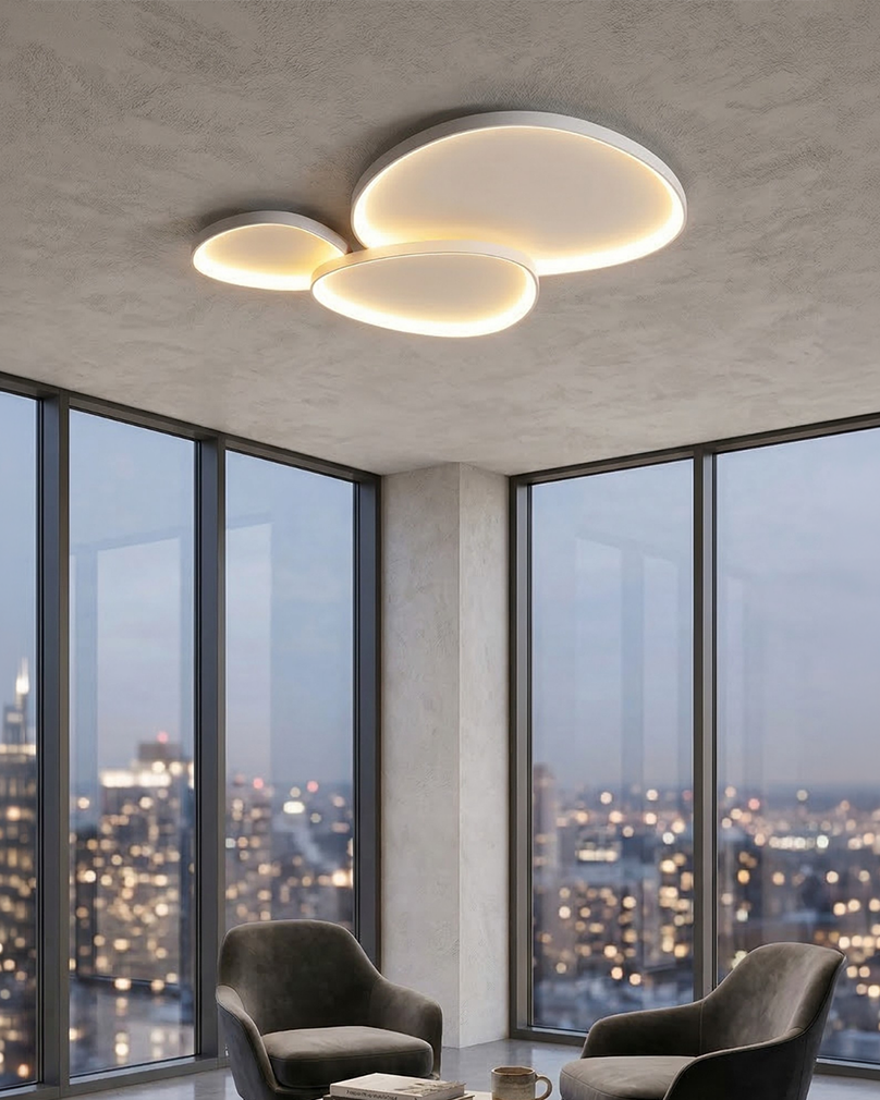 White sculptural ceiling light glowing above lounge chairs at dusk