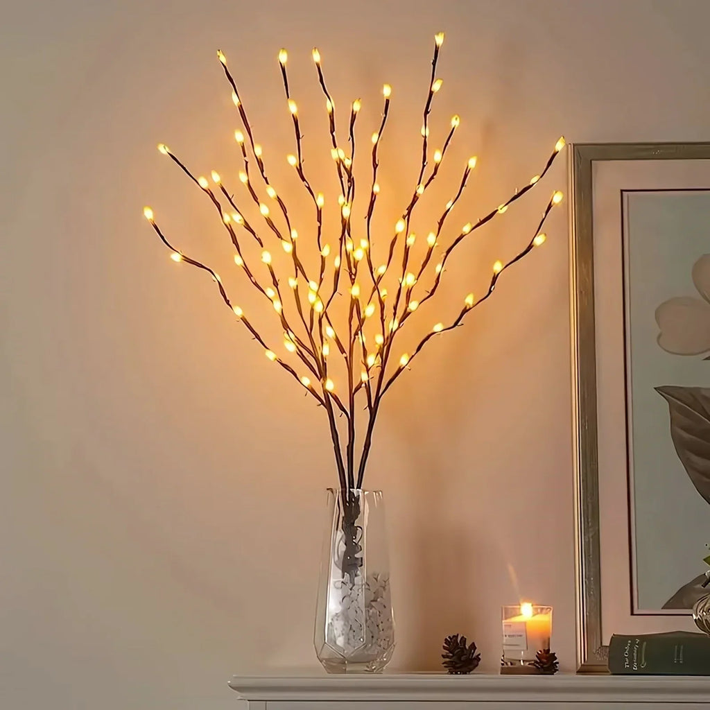 Warm white lighted branch in glass vase on a mantel