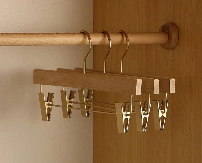 Side view of wooden clip trouser hangers in a closet