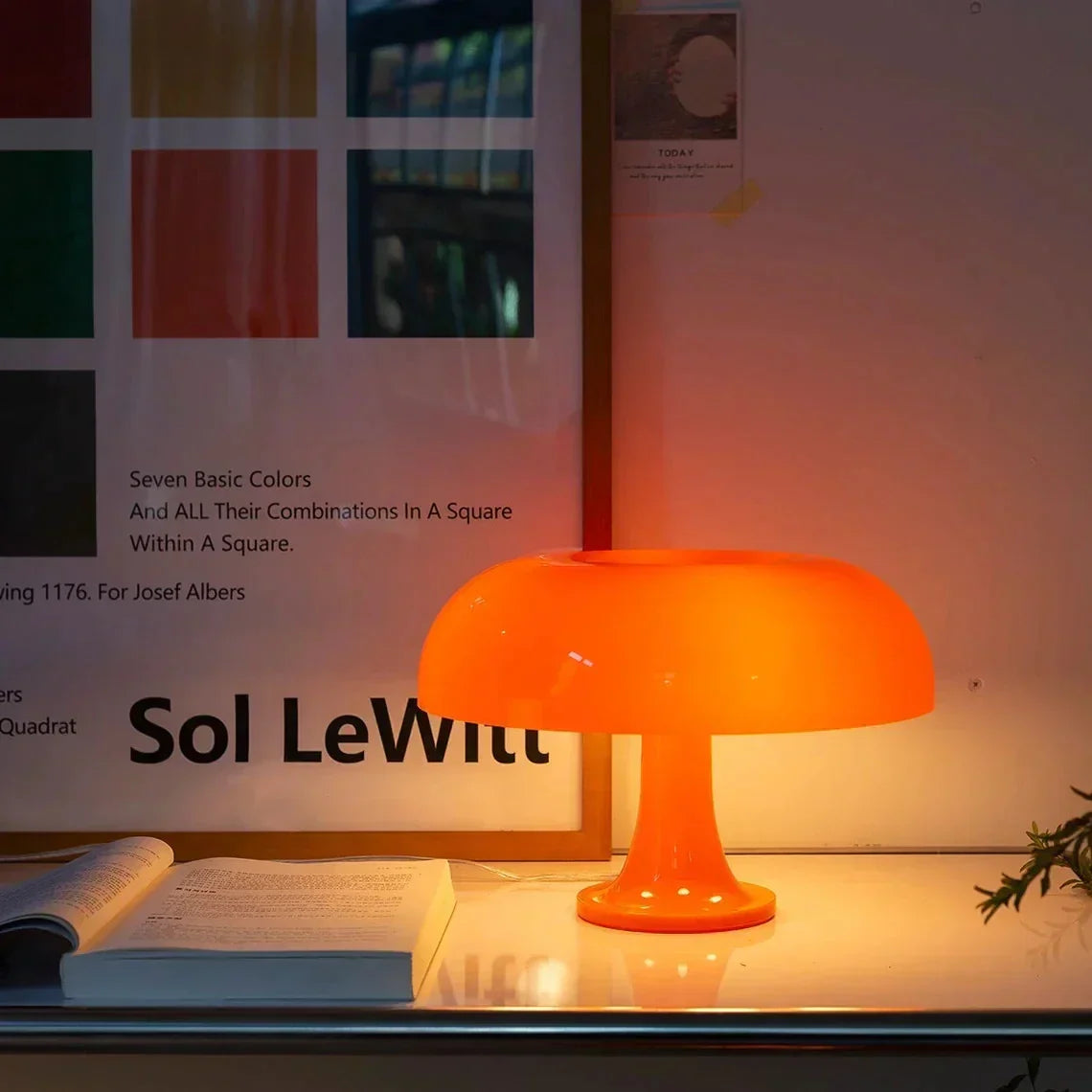 Orange mid century table lamp glowing softly on a shelf at night