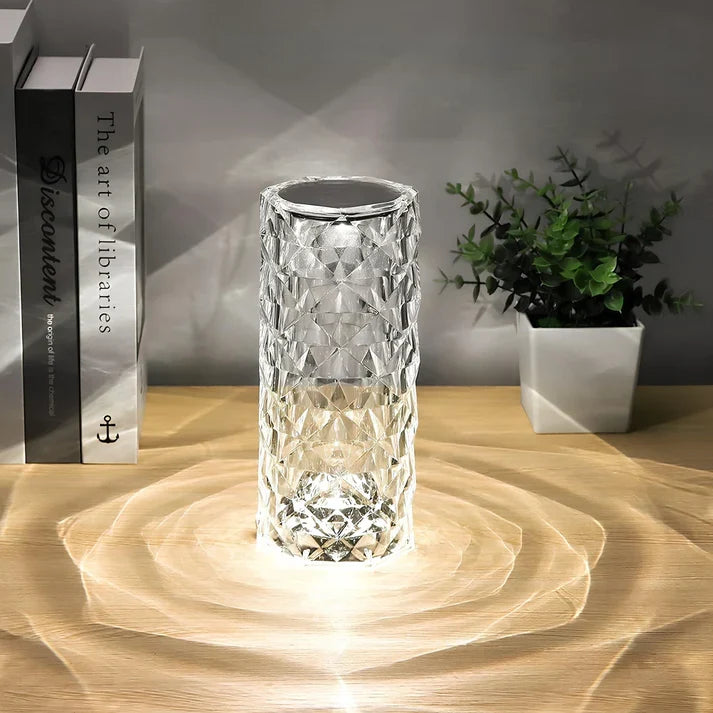 Modern table lamp on a wooden desk with books and plant