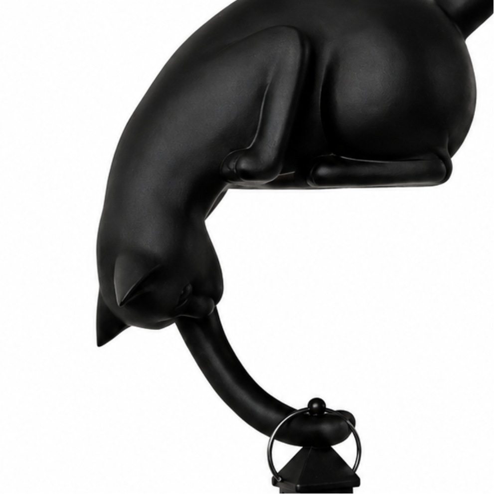 Close-up of matte black cat figurine holding lantern ring