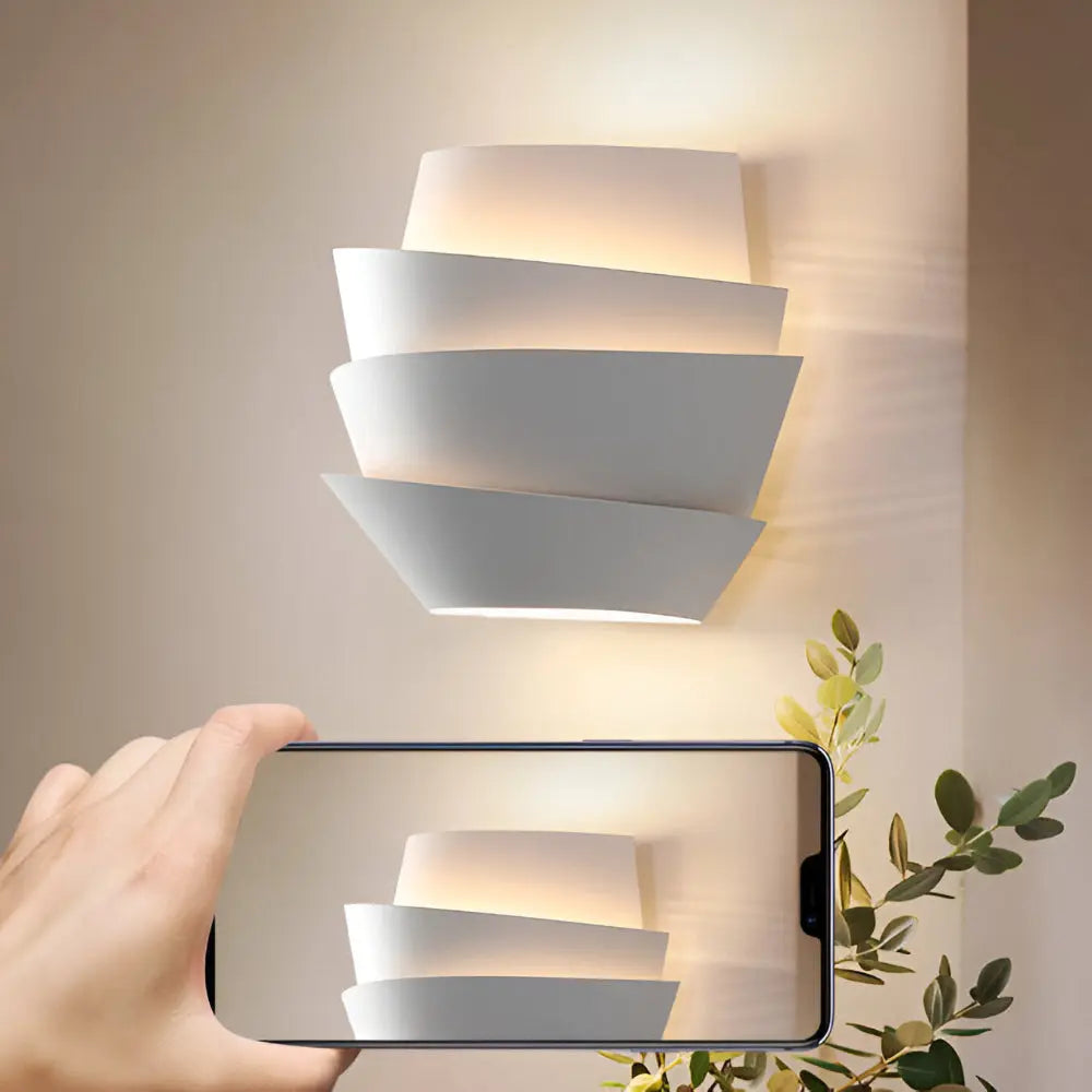 Wall sconce for living room glowing beside a leafy branch