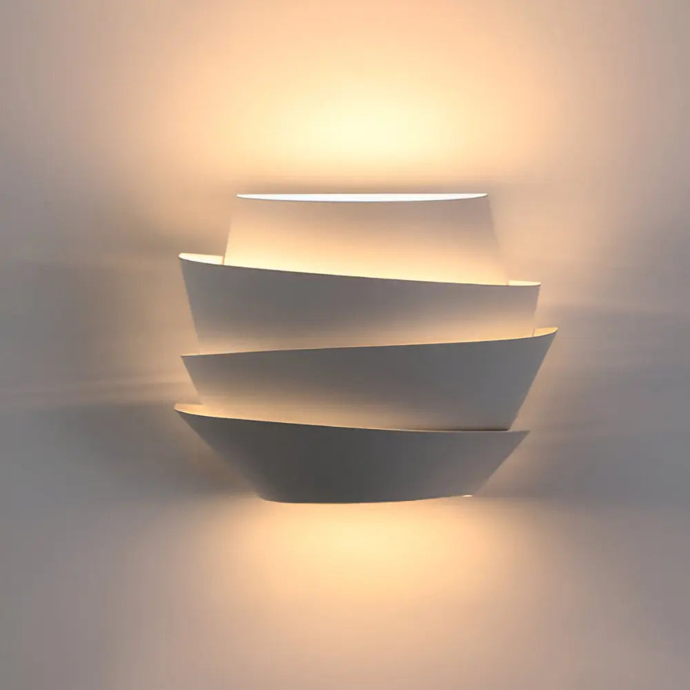 Layered white wall sconce casting soft light up and down