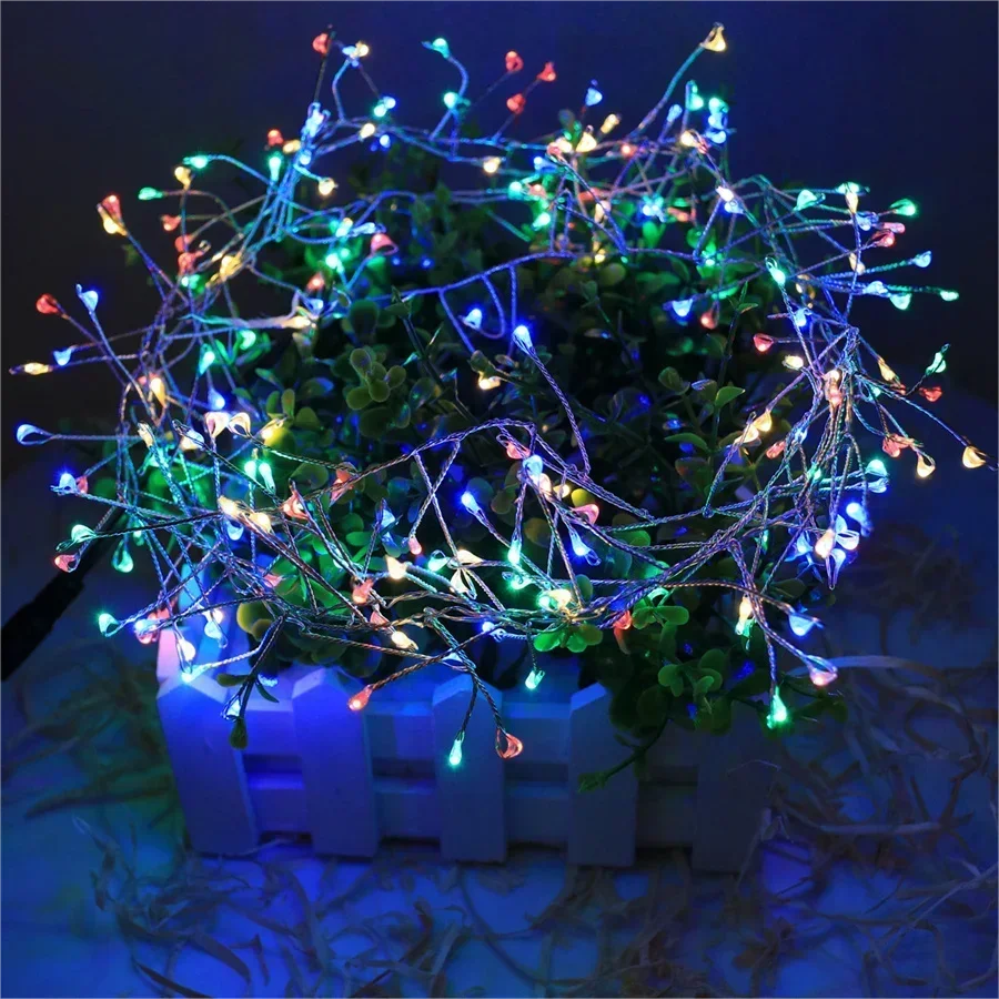 Multicolor decorative string lights wrapped over green potted foliage