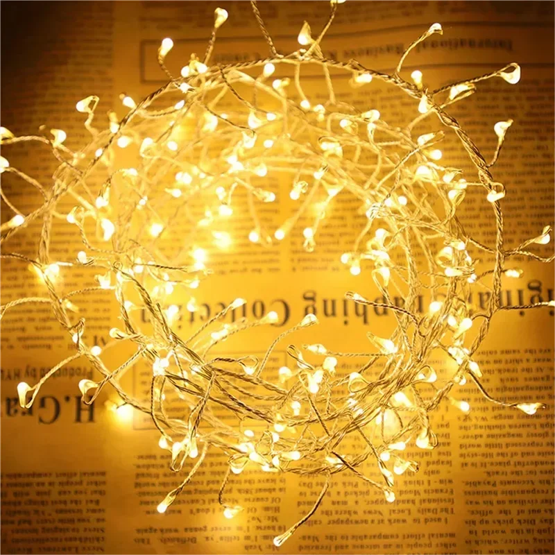 Coiled warm white Christmas lights glowing on vintage newspaper