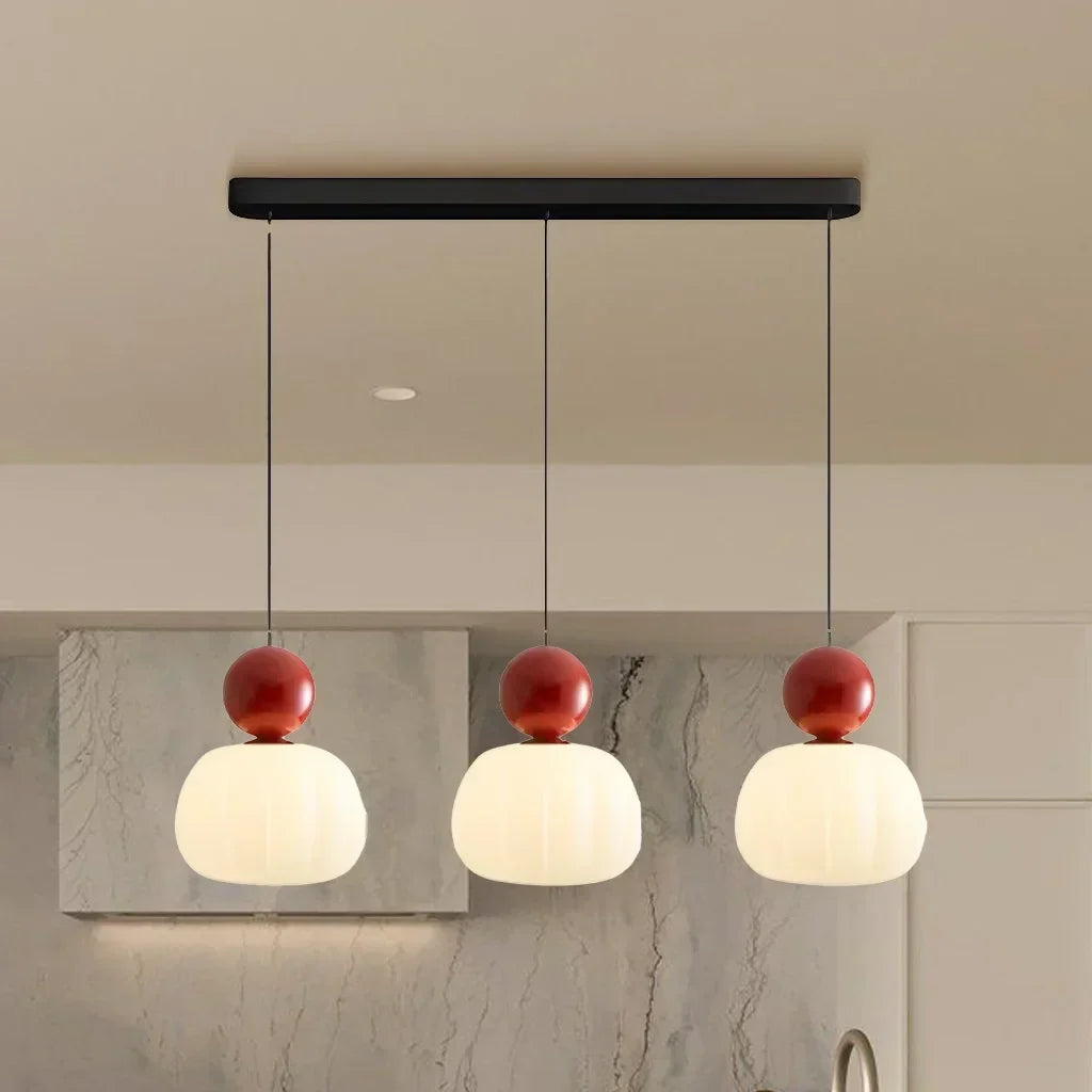 Three Cherry Red pendants above a dining table