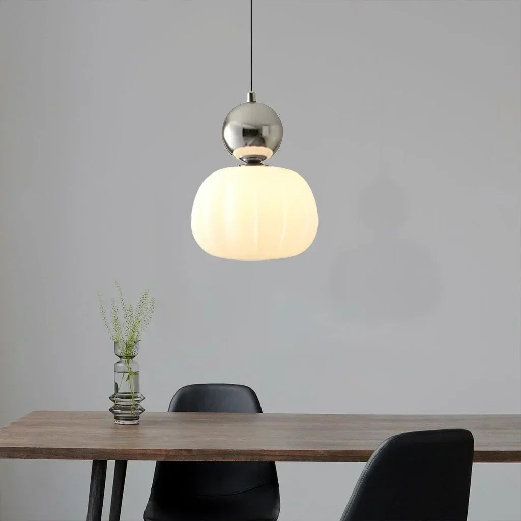 Cream pendant lamp casting warm light in a calm room