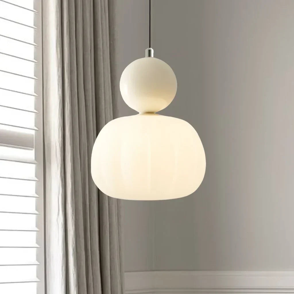 Cream art deco lamp hanging beside a linen curtain