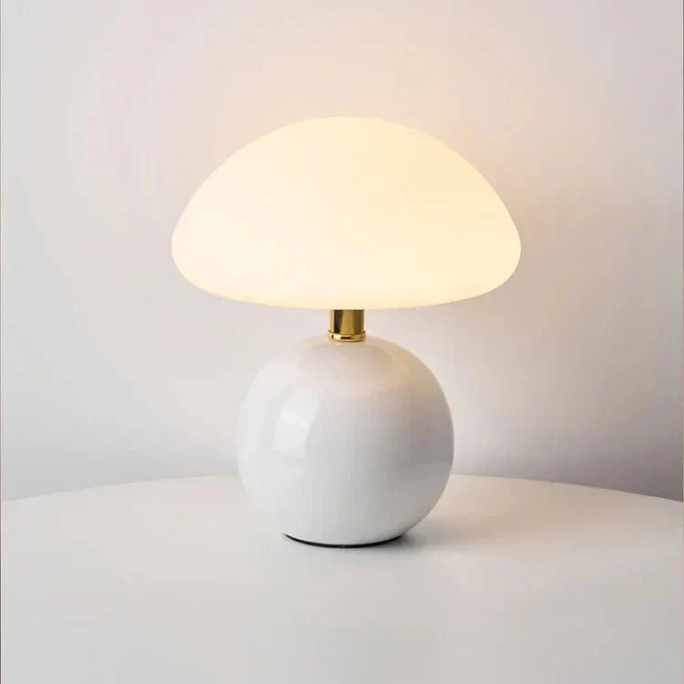 Mushroom lamp on a desk beside a plant and notebook