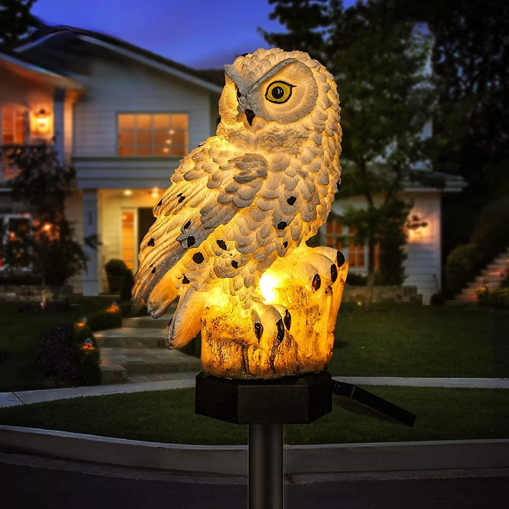 Solar owl landscape light glowing on a front lawn at dusk