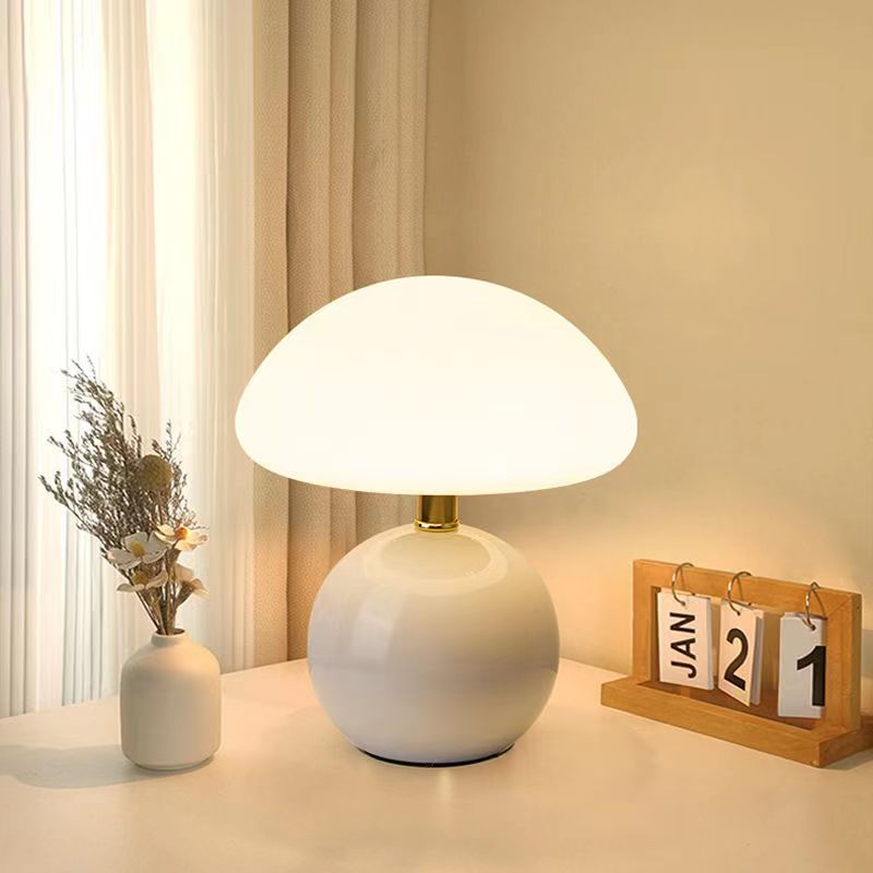 White ceramic lamp with diffused dome shade by sheer curtains